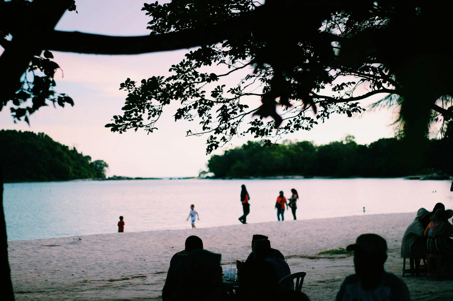 Plaża w Kedah o zachodzie słońca z ludźmi spacerującymi nad morzem