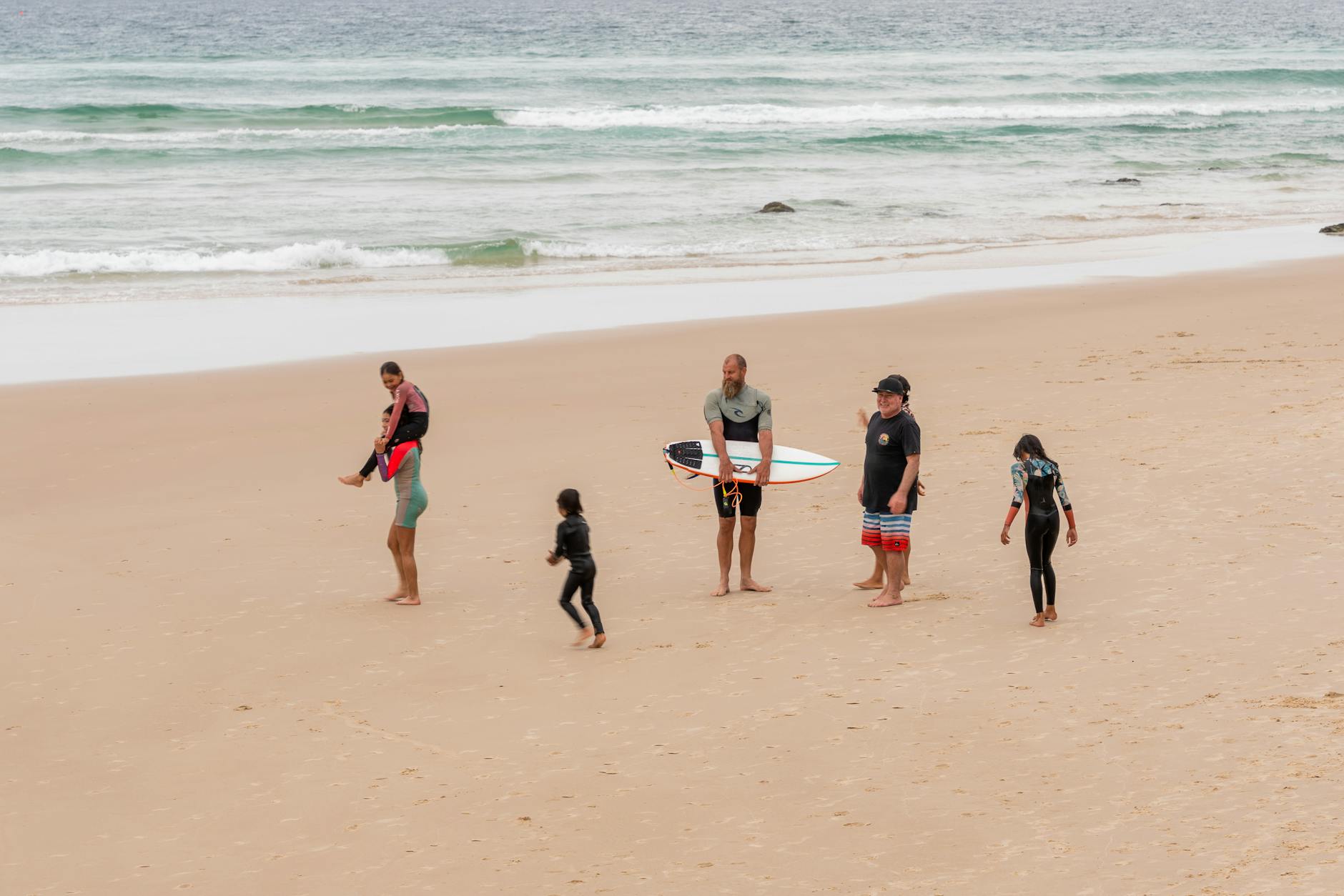 Rodzina z dziećmi z deskami surfingowymi na plaży Gold Coast