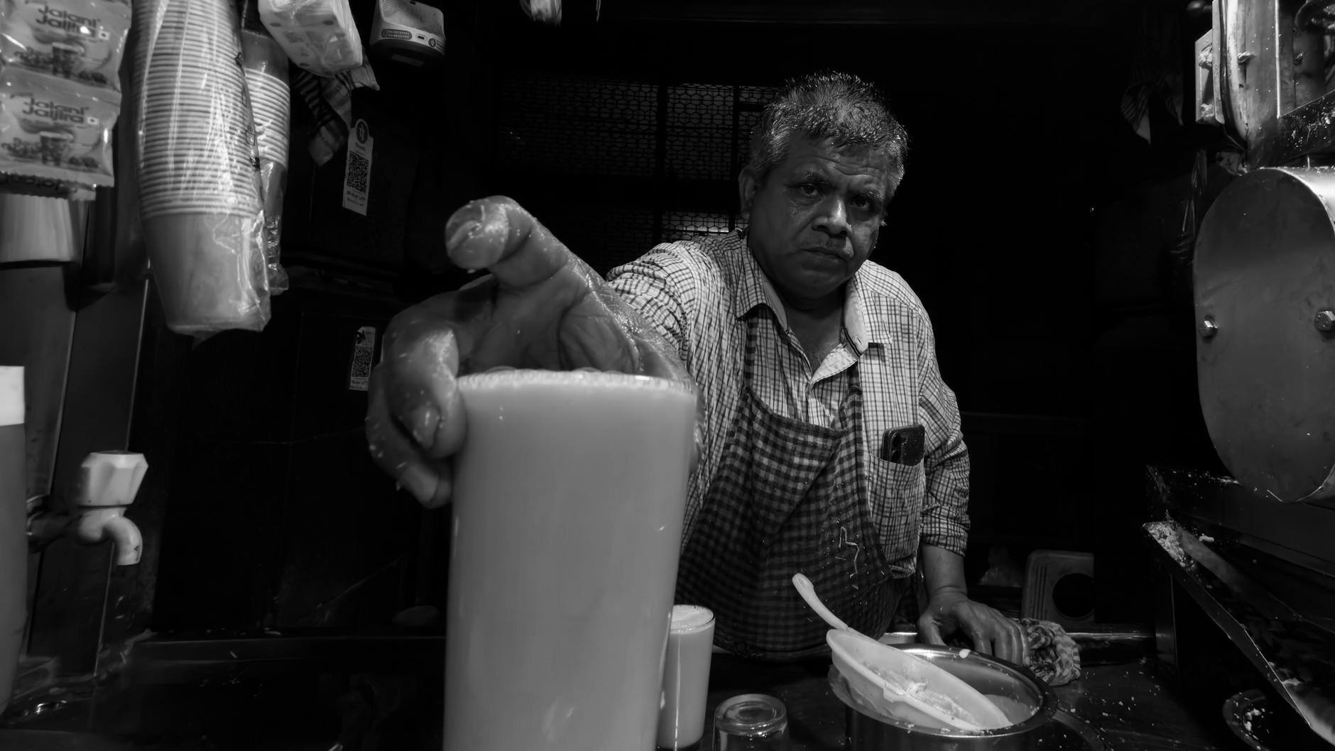 Sprzedawca uliczny w Mumbaju nalewa tradycyjny indyjski napój