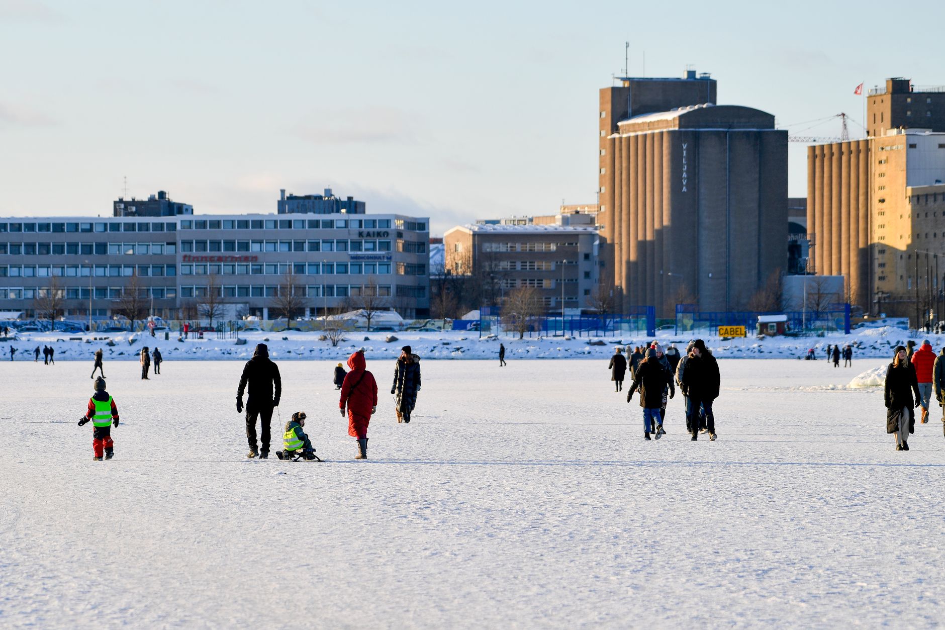 Ludzie spacerują po zamarzniętym morzu w Helsinkach zimą