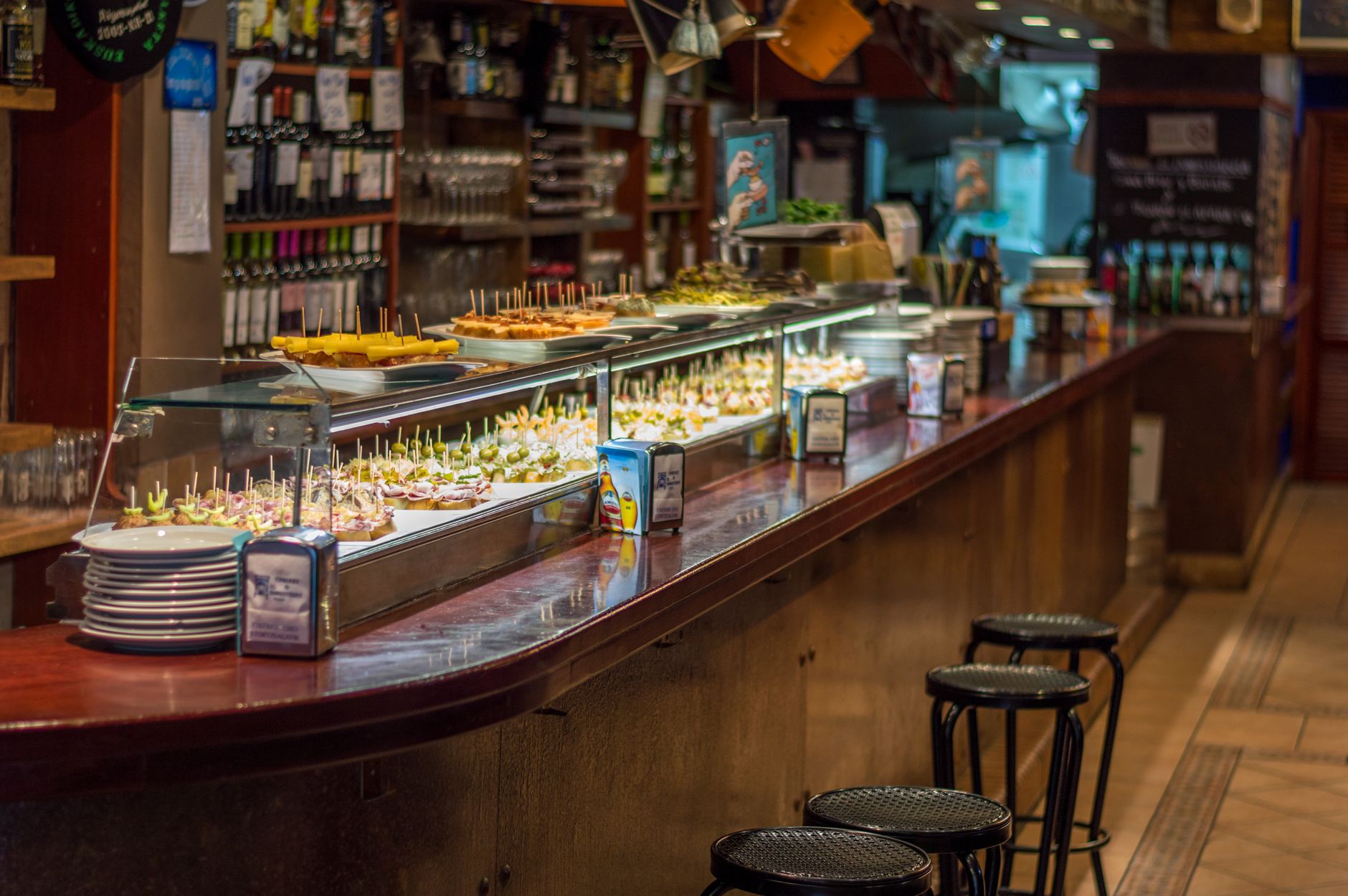 Lada w madryckim barze tapas z kolorowymi pintxos na talerzach