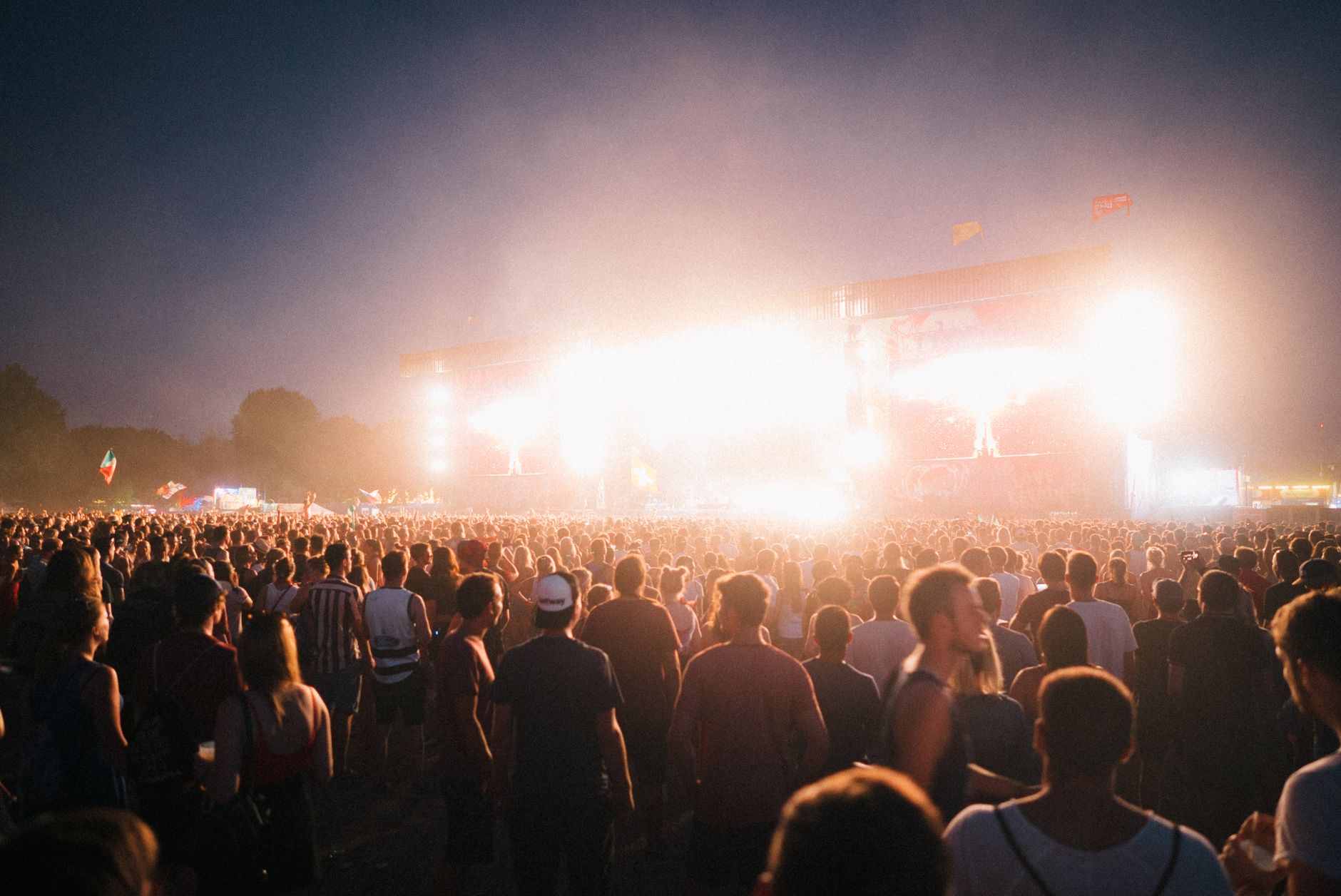 Tłum na nocnym festiwalu muzycznym przy kolorowych światłach sceny