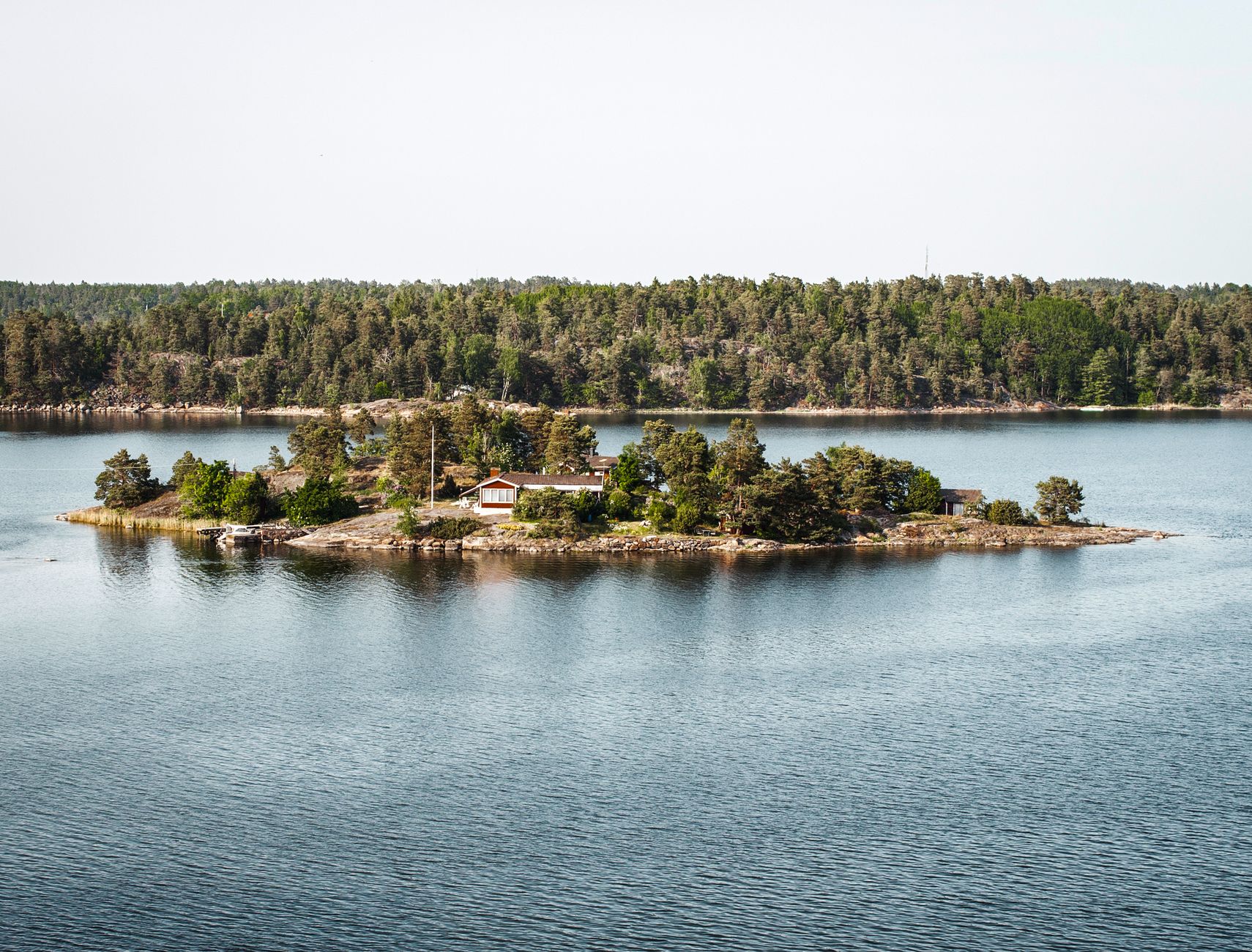 Archipelag sztokholmski: najpiękniejsze wyspy, lokalne smaki i spokojne życie na wodzie Wyspa w sztokholmskim archipelagu z domkiem nad spokojną wodą